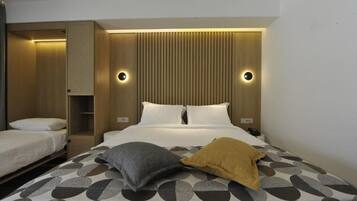 A hotel room with a bed, a bedside table, a wardrobe, and a mirror.