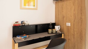 A small, modern room with a wooden wardrobe, a flat-screen TV mounted above a desk, and a framed picture on the wall. - EXPA  (Palermo)