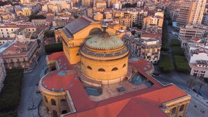 A historic building with a prominent dome and a red-tiled roof, surrounded by urban streets and other buildings. - EXPA  (Palermo)