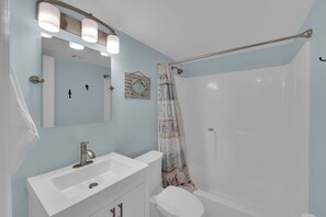 A bathroom with a white sink, a mirror, and a shower curtain. - FUN IN THE SUN! FAMILY ISLAND BEACHFRONT VACATION CONDO! SANDCAPER 409! (Fort Myers Beach)