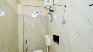 Un baño con inodoro, ducha y secamanos.