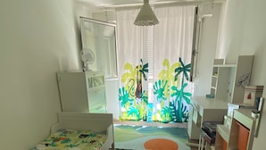 Un dormitorio infantil con literas, un escritorio y una ventana con cortinas.