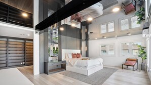 A modern bedroom with a large bed, bedside tables, and a view of the outdoors.