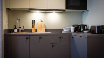 A modern kitchen with a built-in microwave, a coffee maker, and a knife block.
