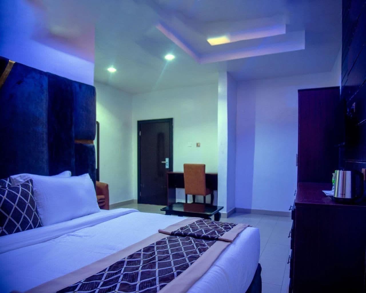 A hotel room with a bed, a desk, and a chair.