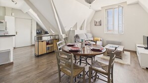 Un loft moderno con comedor, cocina y un ventanal que ofrece vistas amplias.