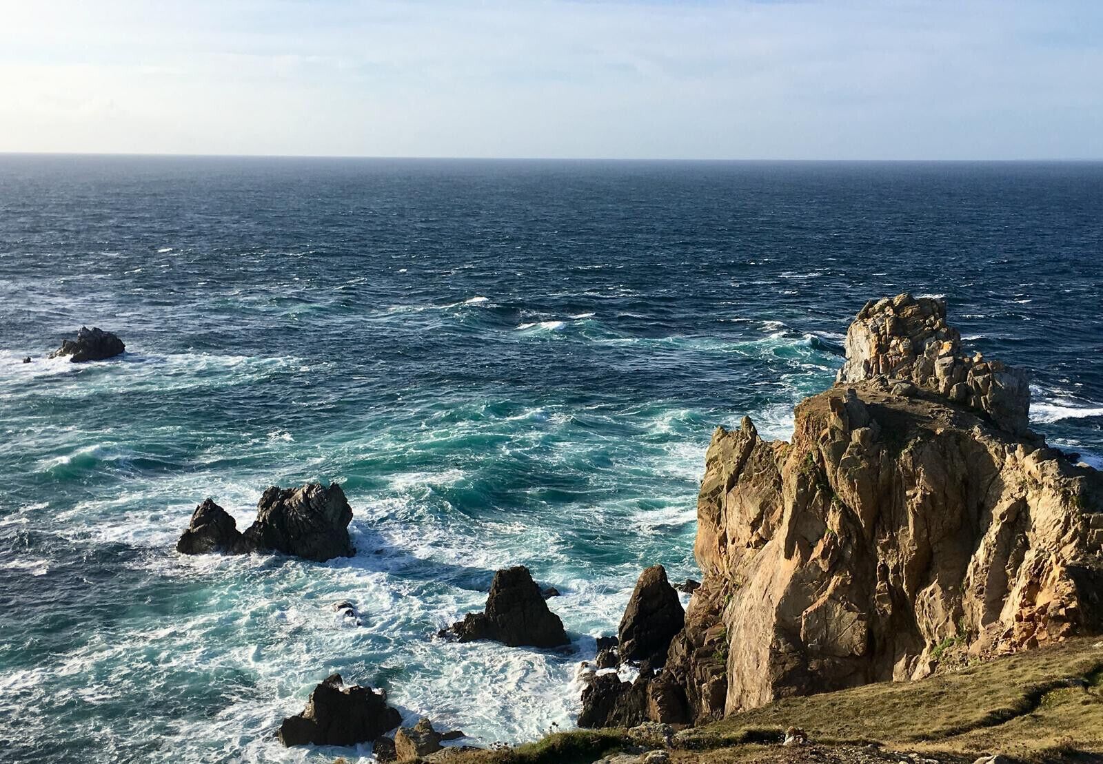 A coastal landscape with rocky outcrops and the sea.