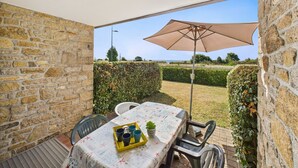 A patio with a table, chairs, and an umbrella. - Sea-view apartment for 2 adults and 3 children (Carnac)