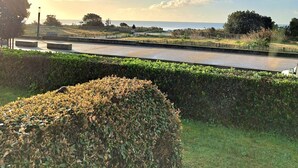 A riverside pathway with a hedge, a lamp post, and a distant view of the sea. - Sea-view apartment for 2 adults and 3 children (Carnac)