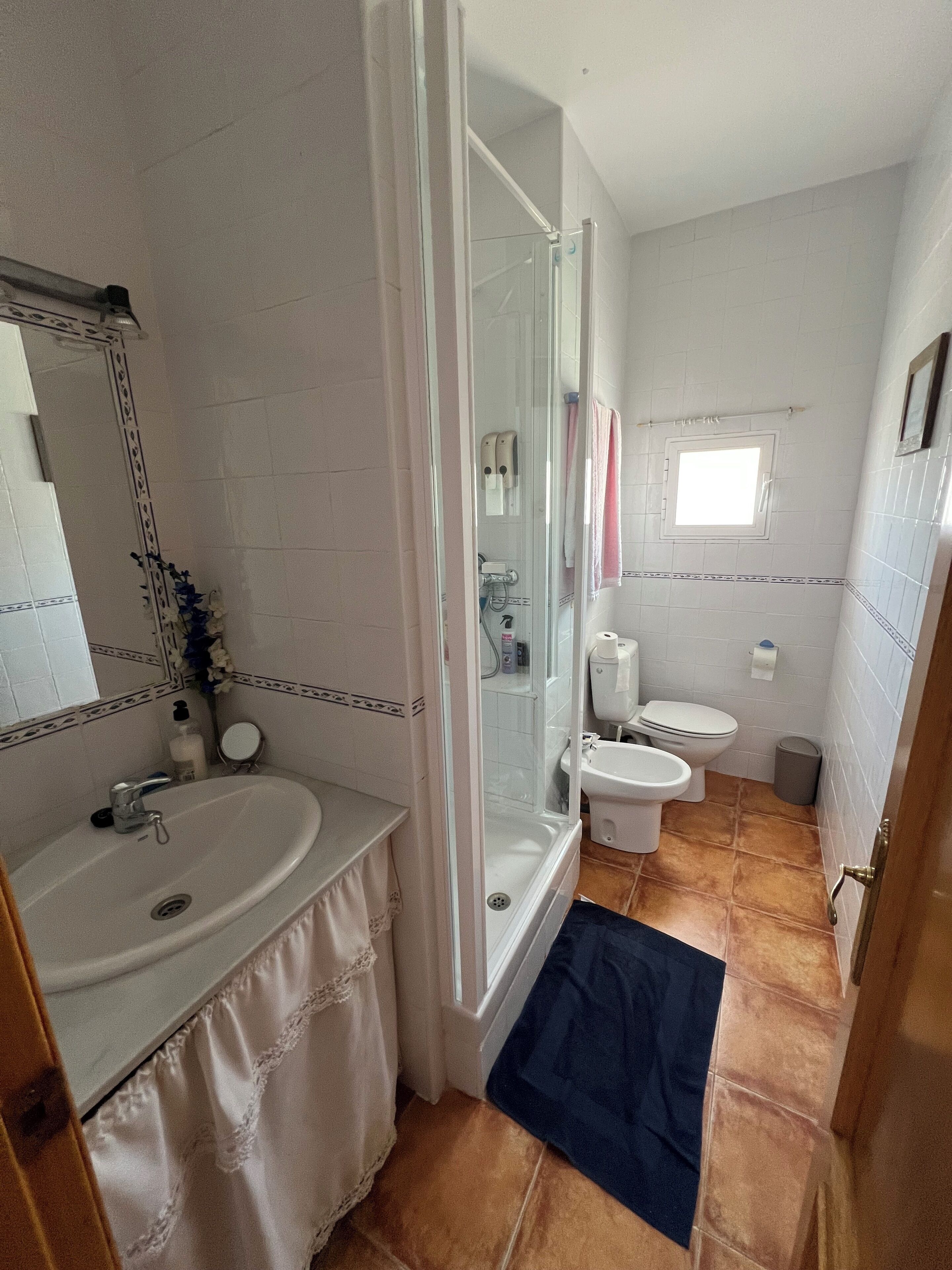 Une salle de bain comprenant un lavabo, des toilettes et un espace douche.