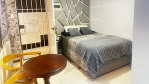 A bedroom with a bed, a bedside table, and a chair. - Whole place near Parque Kennedy (Miraflores)