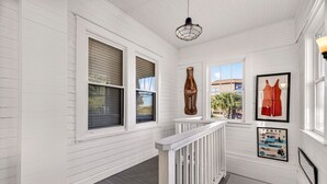 A white wooden interior with a wooden railing, a Coca-Cola bottle, and a Tybee Island poster.