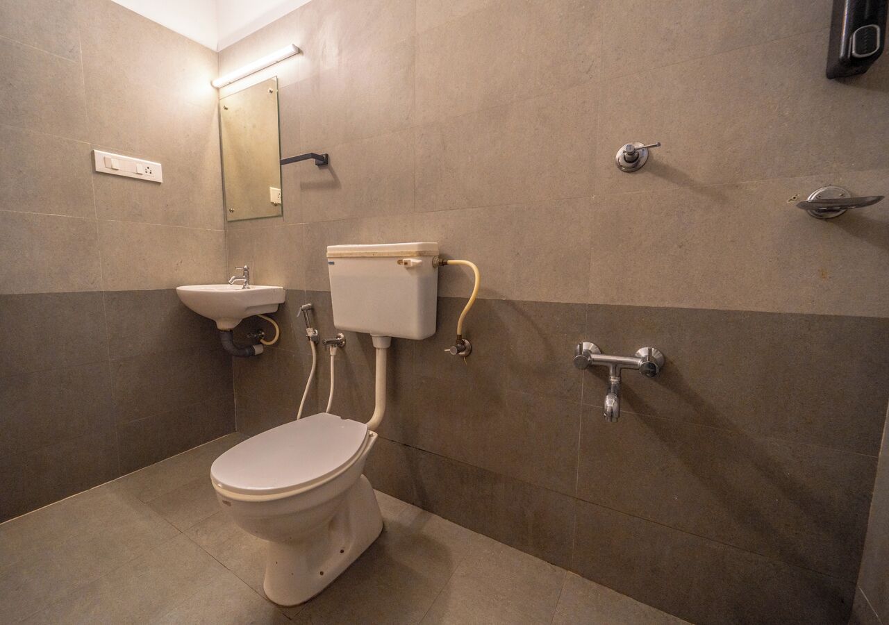 A small, modern bathroom with a toilet, sink, and mirror.