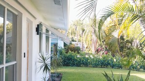 Una casa moderna con un porche cubierto, una jardinera de piedra y un césped bien cuidado.