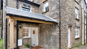 A stone building with a wooden porch and a small entrance.