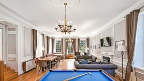 A spacious room with a pool table, a sofa, a dining table, and a chandelier. - Wonderful  villa for 4 guests with hot tub, WIFI, pool, terrace and pets allowed (Northallerton)
