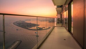A balcony with a view of a waterfront area during sunset. - FIRST CLASS | 2BR | Sea & Palm View | Beachfront (Dubai)