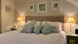 A neatly made bed with white linens and patterned pillows, two bedside tables with lamps, and three framed artworks on the wall. - Stunning  villa for 4 people with WIFI, TV and terrace (Ingleby Greenhow)