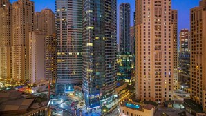 A high-rise urban area with modern buildings, a central roundabout, and illuminated streets. - Stylish 1BR w/ JBR Beach Access, Dubai Marina & Ain Dubai Views (JBR)