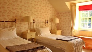 A bedroom with two beds, a window with curtains, and a radiator. - Beautiful  villa for 4 people with WIFI, TV and terrace (Ingleby Greenhow)