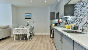 A modern kitchen with grey cabinets, a white countertop, and a herringbone-patterned backsplash. - Beautiful apartment for 4 guests with WIFI, TV and pets allowed (Filey)