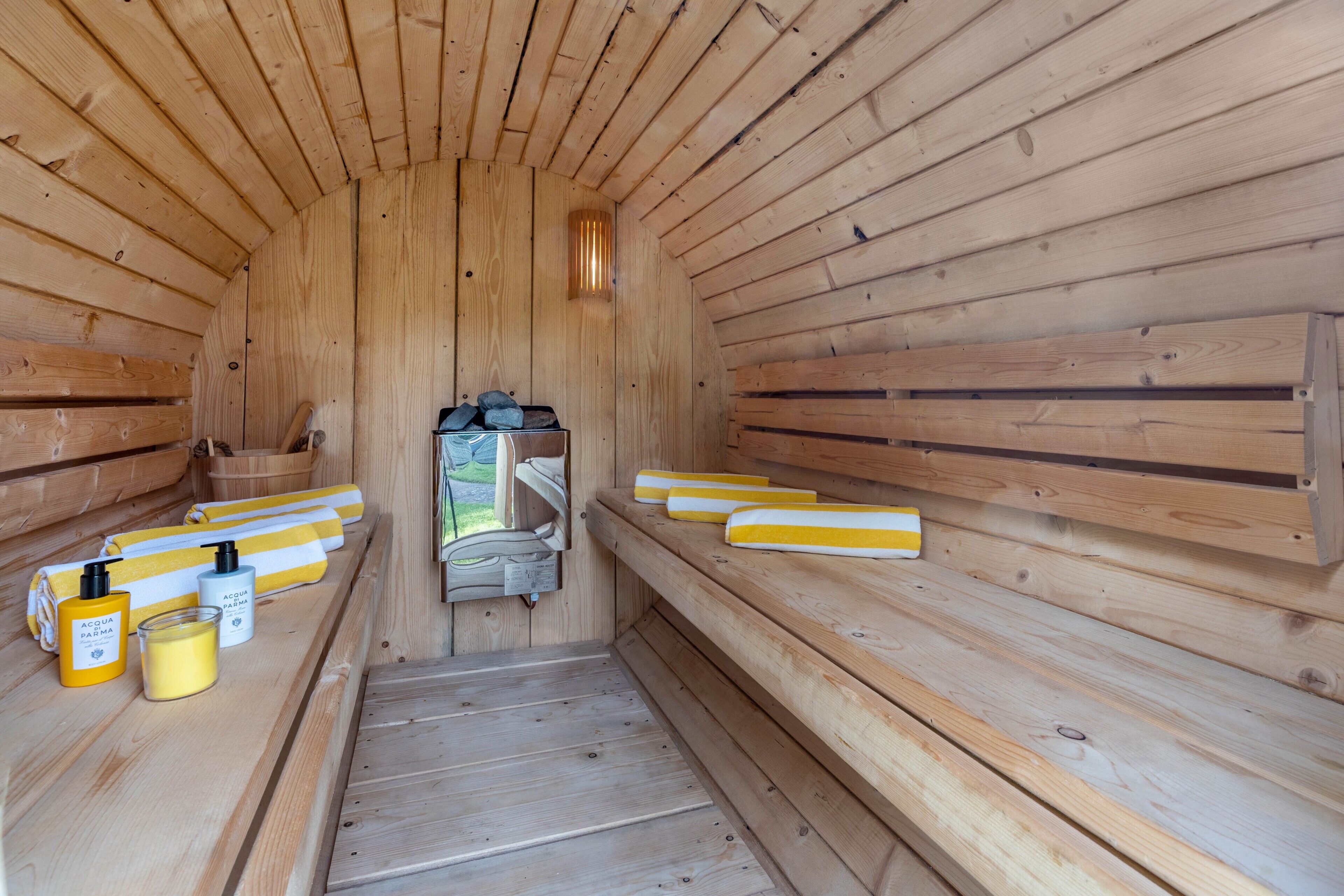 Eine Sauna mit Holzwänden, Bänken und Flaschen Wasser und Seife.