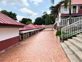 Um corredor com piso estampado que leva a uma escada com guarda-mão de metal.