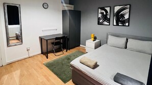A modern bedroom with a bed, a desk, and a chair. - London E1 Hostel (London)