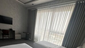 A hotel room with two beds, a desk, and a TV. - The loren hotel (Tashkent)