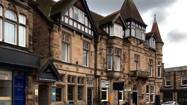 A historic building with multiple stories, large windows, and a prominent tower. - Nice apartment for 2 guests with WIFI and TV (Matlock)
