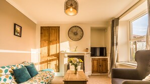 A cozy living room with a sofa, a coffee table, and a TV.