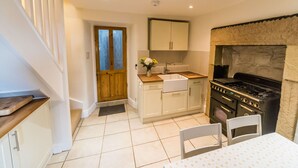 A compact kitchen with a stove, sink, and cabinets.