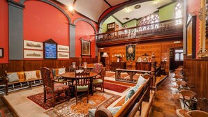 A spacious room with a high ceiling, wooden furniture, and a balcony with ornate railings. - Beautiful  villa for 2 guests with pets allowed (Cromer)