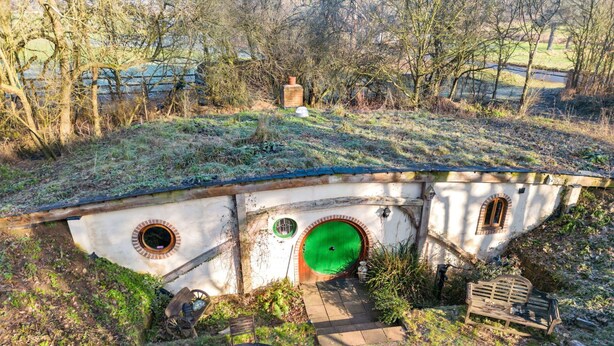 A Hobbit-style house with a green door, a small garden, and a rustic outdoor seating area. - Beautiful  villa for 4 guests with WIFI and pets allowed (Bury St Edmunds)