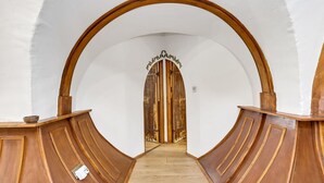 A corridor with a wooden door at the end, flanked by wooden walls and a white ceiling. - Beautiful  villa for 4 guests with WIFI and pets allowed (Bury St Edmunds)