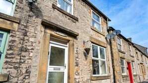 A stone building with a white door and windows, potted plants on the ground, and satellite dishes on the roof. - Beautiful  villa for 4 guests with WIFI, TV and pets allowed (Matlock)