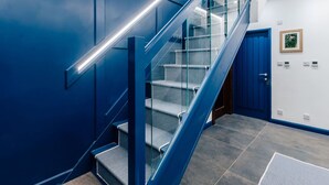 A modern staircase with glass railings and a blue accent wall. - Stunning  villa for 4 guests with WIFI (Ramsey)