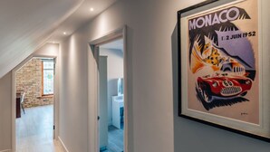 A hallway with a framed Monaco racing car poster, a staircase, and a door leading to another room. - Stunning  villa for 4 guests with WIFI (Ramsey)