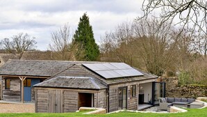 A rustic wooden house with a sloped roof and solar panels.