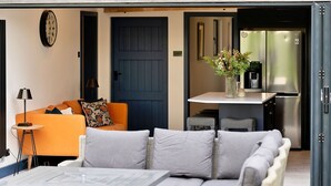 A modern living area with a sofa, a coffee table, and a dining table.