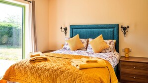 A bedroom with a bed, a nightstand, and a window.