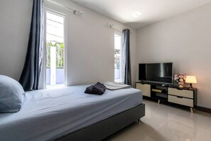 A modern bedroom with a bed, a TV, and a nightstand.