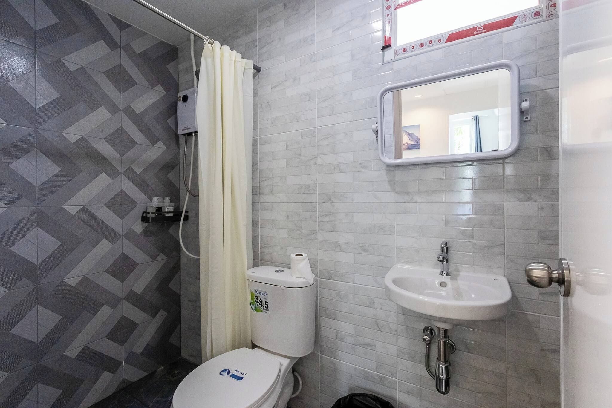 A bathroom with a toilet, sink, and shower.