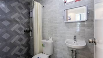 A bathroom with a toilet, sink, and shower.
