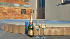 A hot tub with a bottle of champagne and two glasses. - Stunning  villa for 12 guests with WIFI, hot tub and terrace (Nottingham)