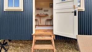 A compact, single-room cabin with a wooden staircase leading to a small dining area. - Beautiful  villa for 2 people with WIFI and pets allowed (Brackley)