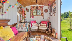 A cozy, rustic room with a wooden ceiling, a large window, and a view of a green landscape. - Stunning  villa for 4 people with pets allowed (Romsey)