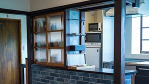 A kitchen with a brick backsplash, wooden counter, and modern appliances. - OMISHIMA SPACE HANARE (Imabari)