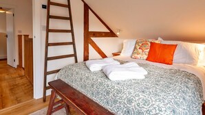 A bedroom with a wooden ladder, a bed with patterned bedding, and a bench. - Wonderful  villa for 4 guests with WIFI, terrace and pets allowed (Chilton Foliat)