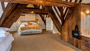 A cozy attic bedroom with exposed wooden beams, a bed, and a small desk area. - Wonderful  villa for 19 people with WIFI, pool, TV and pets allowed (Stroud)